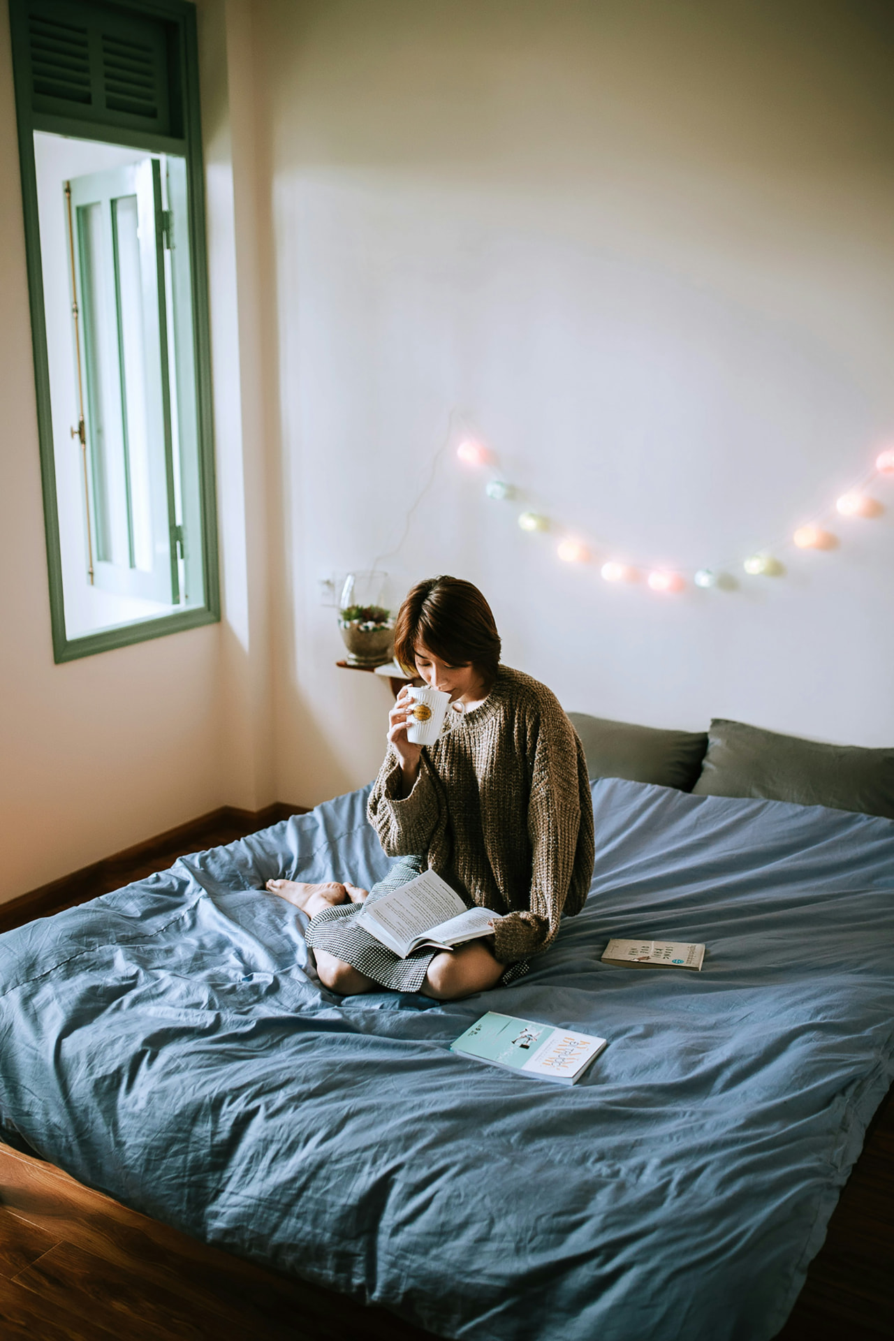 Person reading in bed with a warm drink